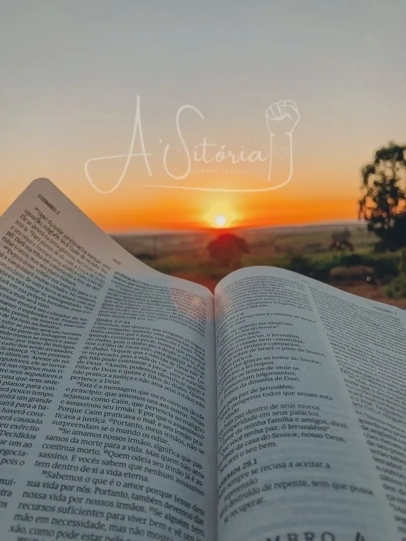 Bíblia aberta diante do pôr do sol no campo