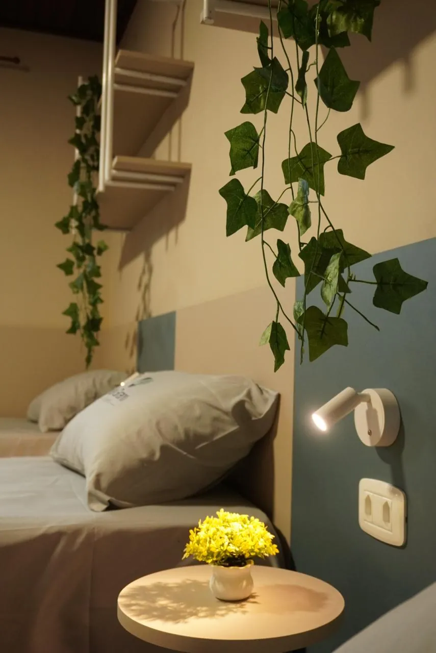 Cabeceira com luminária, flores amarelas e hera pendente